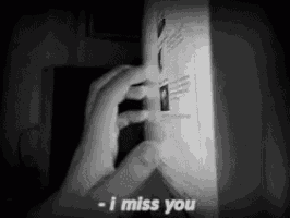 a person is holding a piece of paper that says  i miss you 